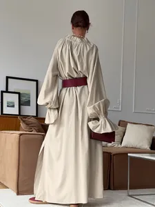 Elegant French style long sleeve beige linen maxi dress with burgundy waist belt back view.