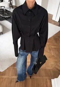 Chic black long-sleeved shirt with a pleated cinched waist and elegant lapel collar design