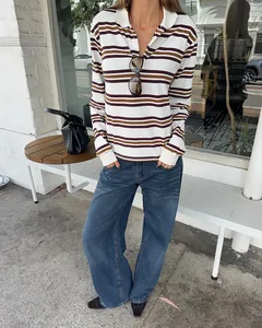 Woman wearing a retro striped long sleeve polo shirt with blue jeans in an urban setting