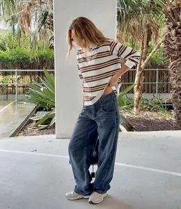 Woman wearing a vintage striped polo shirt with long sleeves and loose fit denim jeans