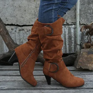 Detailed view of stylish brown suede high boots featuring kitten heels and decorative buckle straps