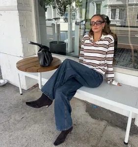 Street style lifestyle shot of a woman wearing a retro striped knit polo shirt