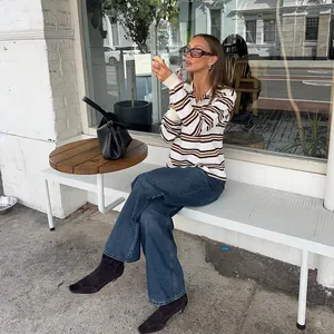 Vintage striped knit polo shirt worn by a model in a stylish outdoor cafe setting