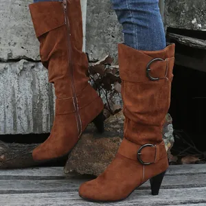 Close-up of brown suede mid-calf boots with elegant buckle detail and high heels
