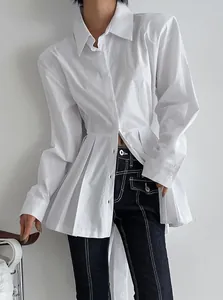 Close-up of white cotton long sleeve shirt featuring pleated waist and button front