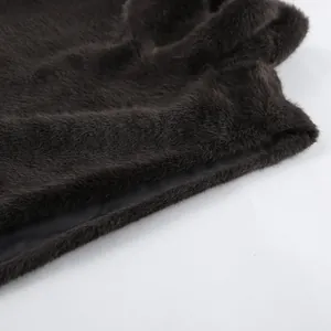 Detailaufnahme der weichen dunkelbraunen Kunstfell-Textur und des Innenfutters einer Weste