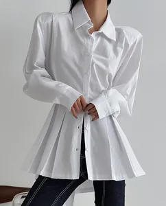 Detail view of white long sleeve cotton shirt with elegant pleated hem and structured shoulders