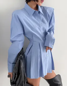 Close-up of blue pure cotton long-sleeved shirt dress with pleated hem and structured shoulders