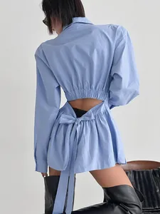 Detail of light blue cotton shirt featuring a stylish back cutout and tie-up bow.