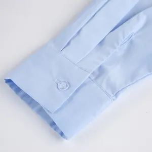Detailed view of a light blue long-sleeved cotton shirt cuff with a single button