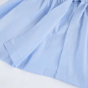 Macro shot of high-quality stitching and light blue cotton fabric on a commuter shirt.