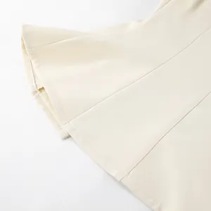 Gedetailleerde weergave van de stiksels op een minimalistische crèmewitte damesblazer