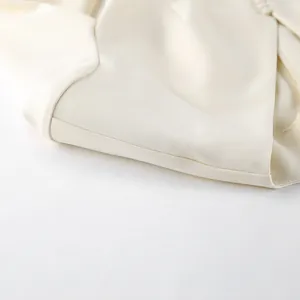 Detailopname van de crèmewitte blazer met hoogwaardige stoftextuur en afwerking
