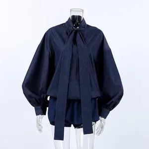 Close-up of navy blue soft denim two-piece set with puff sleeves and bow tie collar