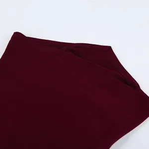 Detailaufnahme des Saums und der Nähte eines weinroten, eng anliegenden Langarm-T-Shirts.