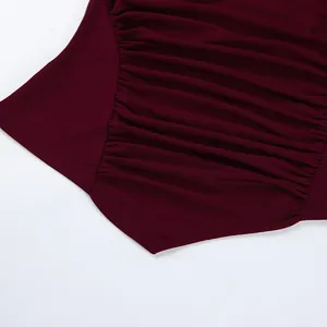 Detailaufnahme des plissierten Designs und des spitzen Saums dieses burgunderroten Oberteils.