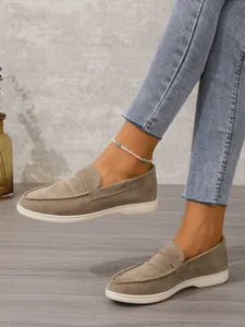 Detailansicht der khakifarbenen Wildleder-Loafer mit flacher weißer Sohle.
