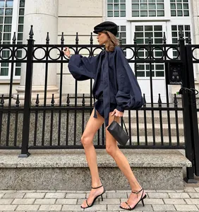 Editorial view of a blue puff-sleeve denim set styled with a baker boy cap.