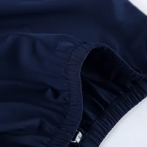 Macro detail showing the elasticated sleeve cuff texture of a navy blue cotton shirt