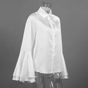 Detalle de elegante blusa de satén blanco con mangas acampanadas