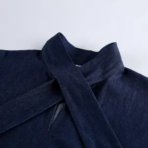 Detail of blue soft cotton denim shirt featuring a cross-neckline design and fine stitching.