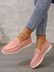 Nahaufnahme der stilvollen rosa Damen-Slipper aus Wildleder mit eleganten Ziernähten.