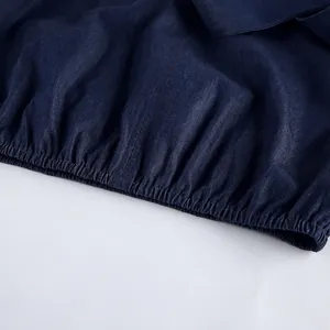 Close-up detail of elasticized hem on soft blue cotton denim garment