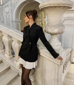 Femme élégante en blazer rétro américain avec ourlet plissé blanc et col en V chic.