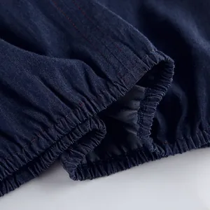 Detailed close-up of elasticated cuff detail on blue soft cotton denim fabric