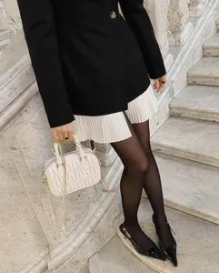 Détail d'une veste blazer vintage pour femme avec ourlet plissé blanc contrastant chic