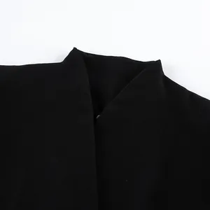 Détail en gros plan du col en V minimaliste sur un blazer vintage noir pour femme
