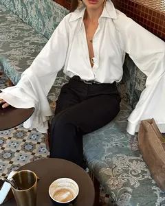 Elegante blusa de satén blanco de estilo francés con mangas de campana acampanadas en un set chic