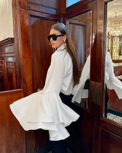 Detalle de blusa de satén blanco con dramáticas mangas de campana de doble capa estilo francés