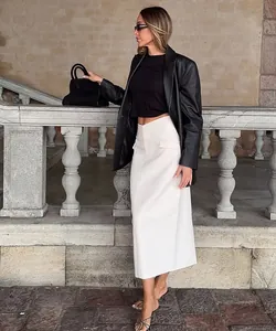 Elegant off-white midi skirt styled with a black leather blazer and chic crop top