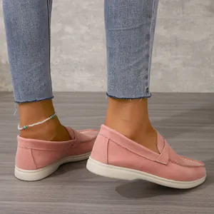 Detailaufnahme der rosa Wildleder-Loafer mit flacher weißer Sohle und Ziernähten
