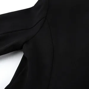 Vue macro montrant les coutures précises et la texture du tissu d'un blazer noir femme