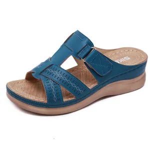 Vue détaillée des sandales compensées bleues avec motifs ajourés et bride velcro