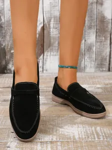 Detailansicht stilvoller Damen-Loafer aus schwarzem Wildleder mit weißen Ziernähten.