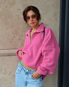 Detaillierte Nahaufnahme des rosa Fleece-Sweatshirts mit halbem Reißverschluss-Kragen