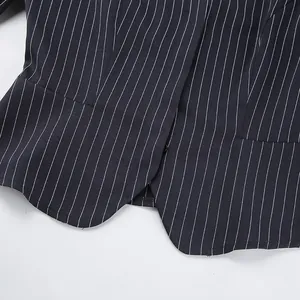 Macro view showing the fine vertical pinstripe texture and curved hem of a navy blazer.