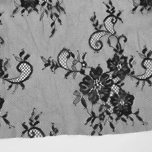 High-resolution close-up of black floral lace fabric with delicate mesh and embroidery texture