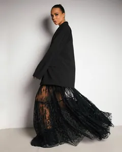 Side view showing flowy texture of black high-waisted lace sheer maxi skirt