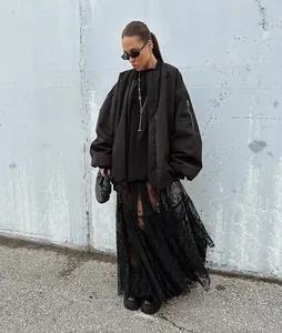 Outdoor street style shot of black lace maxi skirt with sheer detail and oversized jacket