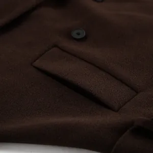 Close-up detail van een donkerbruine wollen jas met hoogwaardige stoftextuur en zwarte knoop