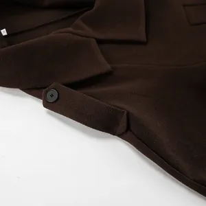 Gedetailleerde close-up van bruine wollen jas kraag met premium stoftextuur en knoop