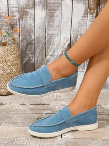 Nahaufnahme der blauen Wildleder-Loafer für Damen mit lässigem Slip-On-Design an den Füßen