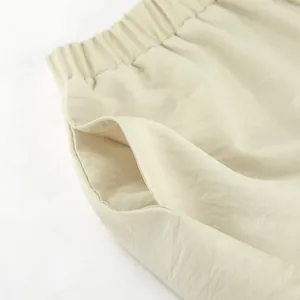 Detailansicht der beigen Shorts mit hohem Bund, elastischem Bund und Seitentasche