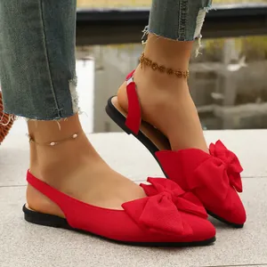 Elegant red pointed-toe flat sandals with a decorative large bow and slingback