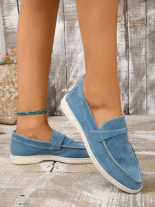 Detailansicht der stylischen blauen Wildleder-Loafer mit dekorativen weißen Nähten