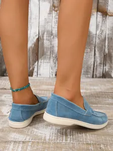 Seitenansicht-Detail von blauen Damen-Slippern aus Wildleder mit flachem Design